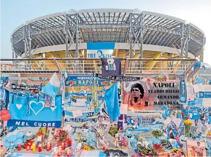  ?? EFE ?? Santuario en el San Paolo. Los hinchas dejaron sus ofrendas en la reja del estadio. Se llamará Maradona.