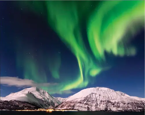  ??  ?? Clockwise from left: Aurora above Tromso; a spectator watching the aurora in Yellowknif­e, Canada; Tromso in Norway; and the landscape in Senja, Norway