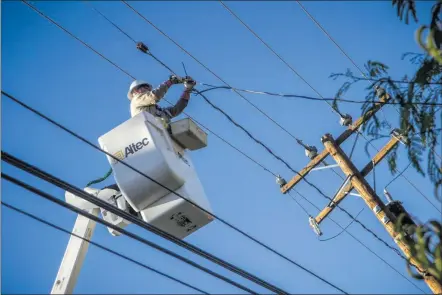  ?? Austin Dave/The Signal ?? A Southern California Edison utility worker repairs a power line. Electrical utilties across the state will switch some customers to payment plans that would charge more when users use power during peak times and charge less when users use it during...