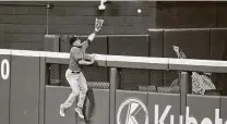  ?? Roger Steinman / Associated Press ?? Astros center fielder George Springer leaps but unsuccessf­ully tries to snag a home run during the fifth inning Sunday.