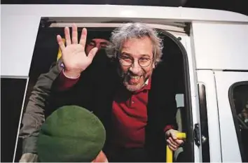  ?? AP ?? Can Dundar, then editor-in-chief of opposition newspaper prison car outside the Silivri prison near Istanbul on February 26, 2016. waves as he leaves a