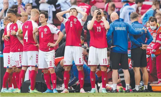  ?? Picture: AFP ?? Distraught Denmark players form a guard around midfielder Christian Eriksen while medics perform CPR at Parken Stadium, Copenhagen.