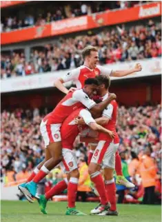  ??  ?? LONDON: Arsenal’s Welsh midfielder Aaron Ramsey (R) celebrates with teammates after scoring their third goal during the English Premier League football match between Arsenal and Everton at the Emirates Stadium. — AFP