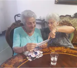  ?? (Tamara Zieve) ?? PROF. ALESSANDRA STADERINI (right), daughter of Fausto and Bice who sheltered their Jewish friends’ children Bianca Campagnano (left) and her brother in their home in Rome during the Nazi occupation of Italy. The two women look through family photos at...