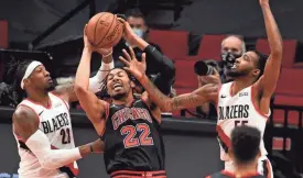  ?? STEVE DYKES/USA TODAY SPORTS ?? Bulls forward Otto Porter Jr. (22) is fouled by Trail Blazers forward Robert Covington (23) as they battle for a rebound with Portland forward Derrick Jones Jr. (55) during the second half on Tuesday.