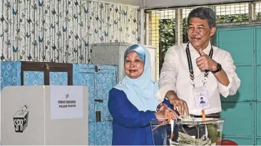  ?? ?? Big win: (Left) mohamad and wife raja datin Seri Salbiah Tengku nujumuddin exercising their right to vote in rantau in this bernama photo. (bottom) Loke ready to place his ballot at the voting centre in SJK (C) Sin Hua.