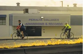  ??  ?? Bicyclists pass the Peralta headquarte­rs. Cycling would be a likely way for some fans to get to ballgames if the A’s stadium ends up being built on the site.