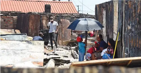  ?? PHANDO JIKELO African News Agency (ANA) ?? A YOUNG boy provides shade for his relatives in Taiwan informal settlement, as residents rebuild their shacks after a fire gutted more than 150 homes and left 400 people destitute on New Year’s Day. |