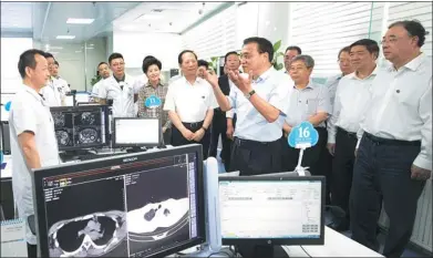  ?? WANG YE / XINHUA ?? Premier Li Keqiang has a look at how the internet is integrated with medical care at Yinchuan No 1 Hospital in Yinchuan, Ningxia Hui autonomous region, on Monday. Local officials said remote diagnoses has improved the local people’s access to healthcare.
