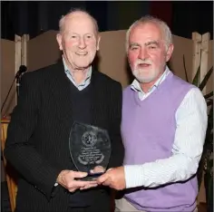  ??  ?? Tom‘Flash’ Dunne receiving honorary life membership of the Wexford and District Women’s Football League from Daire Doyle (Chairman).