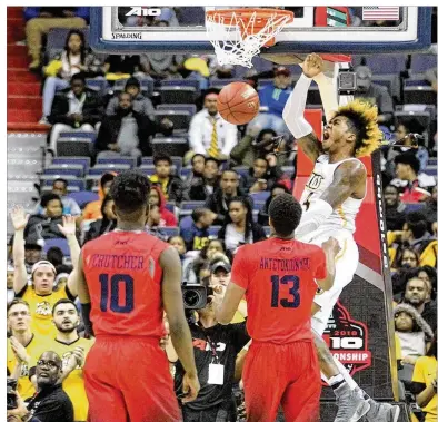  ?? DAVID JABLONSKI / STAFF ?? Dayton freshmen Kostas Antetokoun­mpo and Jalen Crutcher can only watch as VCU’s Justin Tillman dunks during the Flyers’ 77-72 loss in the second round of the Atlantic 10 Tournament on Thursday.