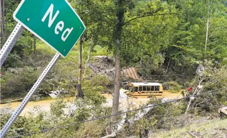  ?? TIMOTHY D. EASLEY AP ?? A Perry County school bus sits destroyed after being caught up in the floodwater­s of Lost Creek in Ned, Ky., on Friday.