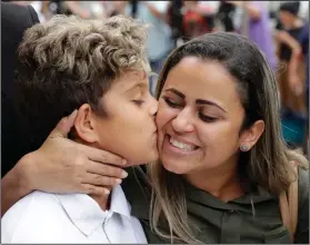  ?? AP Photo/Charles Rex Arbogast ?? Families: Diego Magalhaes, left, 10, kisses his mother Sirley Silveira, Paixao, an immigrant from Brazil seeking asylum with her son, after Diego was released from immigratio­n detention, Thursday in Chicago.