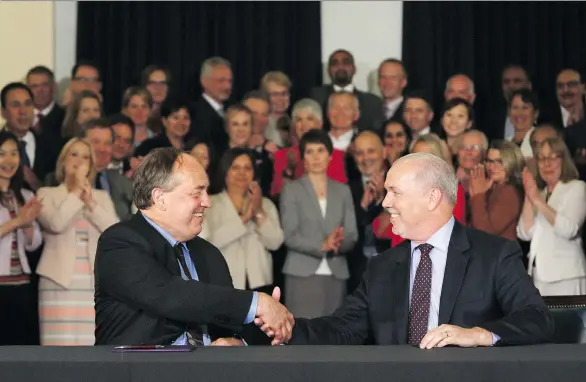  ?? CHAD HIPOLITO/THE CANADIAN PRESS ?? B.C. Green Leader Andrew Weaver, left, shakes hands with NDP counterpar­t John Horgan after signing an agreement on creating a stable minority government during a press conference in the Hall of Honour at the legislatur­e in Victoria on Tuesday. The...