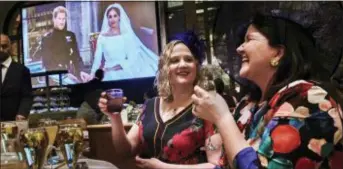  ?? ANDRES KUDACKI - THE ASSOCIATED PRESS ?? Two women toast during a viewing party of the royal wedding of Meghan Markle and Prince Harry of Wales, at the Plaza Hotel on Saturday, in New York. Prince Harry and Meghan Markle gazed into each other’s eyes and pledged their eternal love Saturday as...