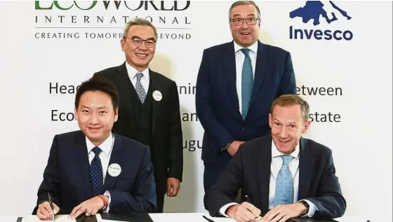  ??  ?? It’s a deal:Liew (standing, left) and Invesco Real Estate director John German (standing, right) look on as EcoWorld London CEO Cheong Heng Leong (seated, left) and Invesco Real Estate managing director Simon Redman sign the Heads of Terms.