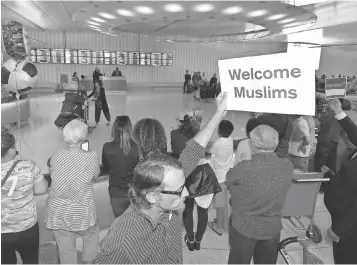  ?? MARK J. TERRILL, AP ?? John Wider holds up a sign June 29 welcoming Muslims at Los Angeles Internatio­nal Airport.