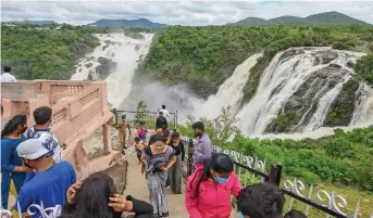  ?? — PTI ?? Tourists visit Gaganachuk­ki Falls gushing with after water was released from Kabini Dam following heavy rainfall in neighbouri­ng Kodagu district in Mandya district on Friday.