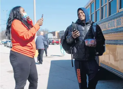  ?? KYLE TELECHAN/POST-TRIBUNE PHOTOS ?? Gary Councilwom­an Tai Adkins takes video of West Side Leadership Academy varsity guard Quimari Peterson as the team departs Friday for its semistate game.