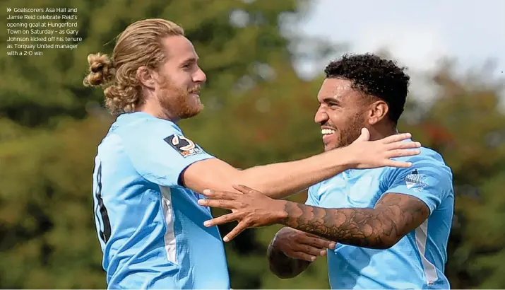  ??  ?? Goalscorer­s Asa Hall and Jamie Reid celebrate Reid’s opening goal at Hungerford Town on Saturday – as Gary Johnson kicked off his tenure as Torquay United manager with a 2-0 win