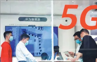  ?? YIN LIQIN / CHINA NEWS SERVICE ?? Shoppers try out Huawei’s 5G products at a store in Shanghai.