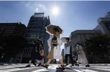  ?? KYODO/VNA Photo ?? HEAT WAVE: People move under the scorching sun in Nagoya, Japan, on July 1, 2022.