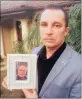  ??  ?? DEVASTATED: Marco Paulo holds a picture of his dad, Jorge Paulo, 61, who was attacked at a restaurant in Hillcrest and died months later in hospital.