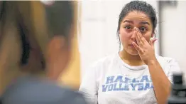  ??  ?? Alexa Gomez wipes away tears after finding out that she made Harlan High School’s first varsity volleyball team. Gomez is a libero.