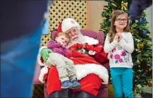  ?? JAHI CHIKWENDIU/WASHINGTON POST ?? Santa Tom with Wyatt Padden, 2, Claire Padden, 5, and other preschool children at Cloverdale School. His beard is real — and he gets it bleached, toned and curled at a salon every two weeks.