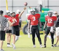  ??  ?? UCF quarterbac­ks Dillon Gabriel, left; Brandon Wimbush, center; and Quadry Jones, right, line up for drills during preseason camp.