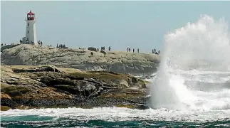  ?? REUTERS ?? Waves crash over the rocks near the lighthouse at Peggy’s Cove in Nova Scotia.