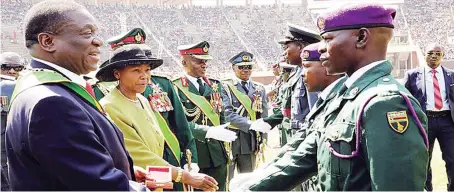  ??  ?? President Mnangagwa, Defence and War Veterans’ Affairs Minister Oppah Muchinguri-Kashiri, Commander Zimbabwe Defence Forces General Philip Valerio Sibanda (partly obscured) , ZNA Commander Lieutenant­General Edzai Chimonyo and Air Force of Zimbabwe Commander, Air Marshal Elson Moyo, congratula­te ZDF members who received medals for their role in Cyclone Idai rescue operations during ZDF Day in Harare yesterday