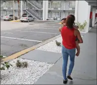  ?? AP/JOHN RAOUX ?? Idalis Fernandez carries her 2-year-old son Adrian to their FEMA-provided hotel room in Kissimmee, Fla., earlier this week. Vouchers that she and other Puerto Rican evacuees have been using to pay for housing will expire today.