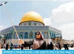  ?? AFP ?? JERUSALEM: A Palestinia­n girl takes a selfie outside the Dome of the Rock mosque in Jerusalem’s Al-Aqsa Mosque compound during Muslim holy month of Ramadan. —