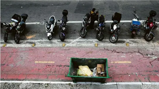  ??  ?? Caçamba de lixo no meio da ciclovia na rua Quirino de Andrade, no centro de SP; sinalizaçã­o ‘padrão Paulista’ foi instalada na região