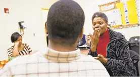  ?? DAILY PRESS FILE ?? Betty Walton, right, a speech language pathologis­t of Clear Speech Now, works with a program participan­t, center, who has an intellectu­al disability, at the day support program in Hampton.