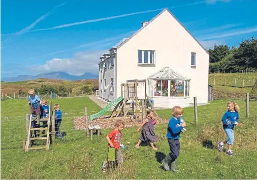  ??  ?? COMMUNITY: Pupils play outside Muck Primary, on a remote Scottish island measuring just two miles long and one mile wide