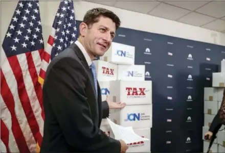  ?? J. SCOTT APPLEWHITE — THE ASSOCIATED PRESS ?? Speaker of the House Paul Ryan, R-Wis., points to boxes of petitions supporting the Republican tax reform bill that is set for a vote later this week as he arrives for a news conference Tuesday on Capitol Hill in Washington.