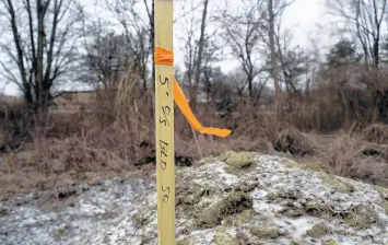  ?? MICHAEL GARD/ POST-TRIBUNE ?? A surveyor’s marker stands on the property in Merrillvil­le where Leslie Corona, of Gary, will build a home with Habitat for Humanity.