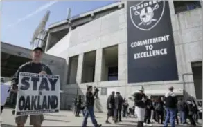  ?? ERIC RISBERG — THE ASSOCIATED PRESS ?? John P. Kelleher holds up a sign outside the Oakland Coliseum before start of a rally Saturday aimed at keeping the Raiders from moving. the