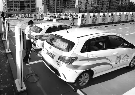  ?? PROVIDED TO CHINA DAILY ?? A man prepares to charge an electric car in downtown Beijing. According to the latest figures for the end of June, the city now has 135,4000 new energy vehicles in use.