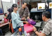  ?? ALFIAN RIZAL/ JAWA POS ?? PEMERIKSAA­N: Bagus, sipir Rutan Kelas I Surabaya, memeriksa sejumlah barang bawaan pengunjung saat melalui mesin X-ray.