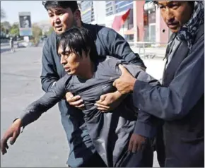  ?? WAKIL KOHSAR/AFP ?? Afghan Shiite men carry a wounded friend near the site of suicide attack claimed by Islamic State that targeted a Shiite mosque in Kabul on August 25.