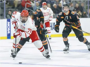  ?? ?? Macklin Celebrini (71), des Terriers de l’Université de Boston, déjoue avec la rondelle Elijah Gonsalves (16), de Rochester, lors d’un match régional du tournoi de hockey universita­ire masculin de la NCAA le jeudi 28 mars 2024, à Sioux Falls, au Dakota du Sud.- Archives