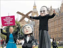  ?? Frank Augstein Associated Press ?? FOES SAY the deal would give the Murdoch family too much inf luence over news in Britain. Above, a protest includes a likeness of Prime Minister Theresa May.
