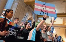  ?? LUKE JOHNSON/USA TODAY FILE ?? People protest against a bill proposing a total ban on affirming care for transgende­r youth, while the Indiana House public health committee conducts a hearing last year in the Indiana State Capitol.