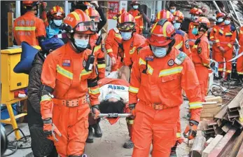  ?? GUO LILIANG / FOR CHINA DAILY ?? Rescuers transport a survivor who was removed on Sunday from the debris of an eight-story building that collapsed in Changsha, Hunan province, on Friday. Seven survivors had been rescued as of Sunday evening, and 16 other people were believed to be trapped inside.