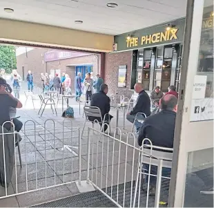  ??  ?? Customers in the covered area outside The Phoenix in Glenrothes.