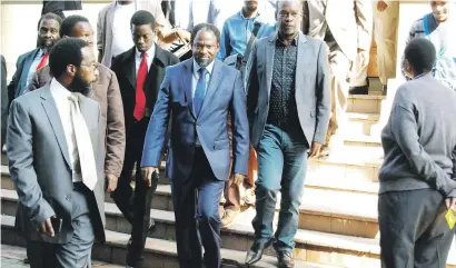  ?? Picture: Phumlani Thabethe ?? UNTIL JUDGMENT. In the centre wearing a navy suit, Thembezinh­le leader Vela Shembe leaves the High Court in Durban with his followers yesterday.