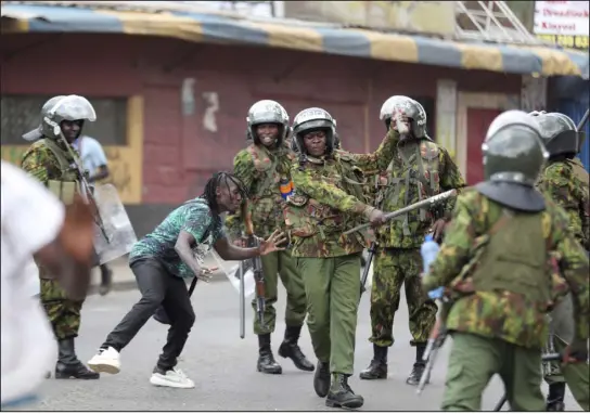  ?? PHOTOS BY BRIAN INGANGA — ASSOCIATED PRESS FILE ?? A police officer strikes a man during a protest over the high cost of living and alleged stolen presidenti­al vote in March in Nairobi. The United States is praising Kenya’s interest in leading a multinatio­nal force in Haiti. But weeks ago, the U.S. openly warned Kenyan police officers against violent abuses.